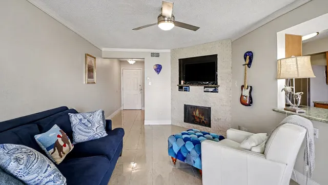 a living room with furniture a flat screen tv and a fireplace
