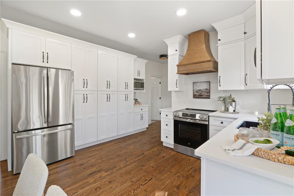 11125 Linbrook Lane Johns Creek, GA 30097 - Photo 21 of 44 a kitchen with stainless steel appliances granite countertop a refrigerator sink stove and white cabinets with wooden floor