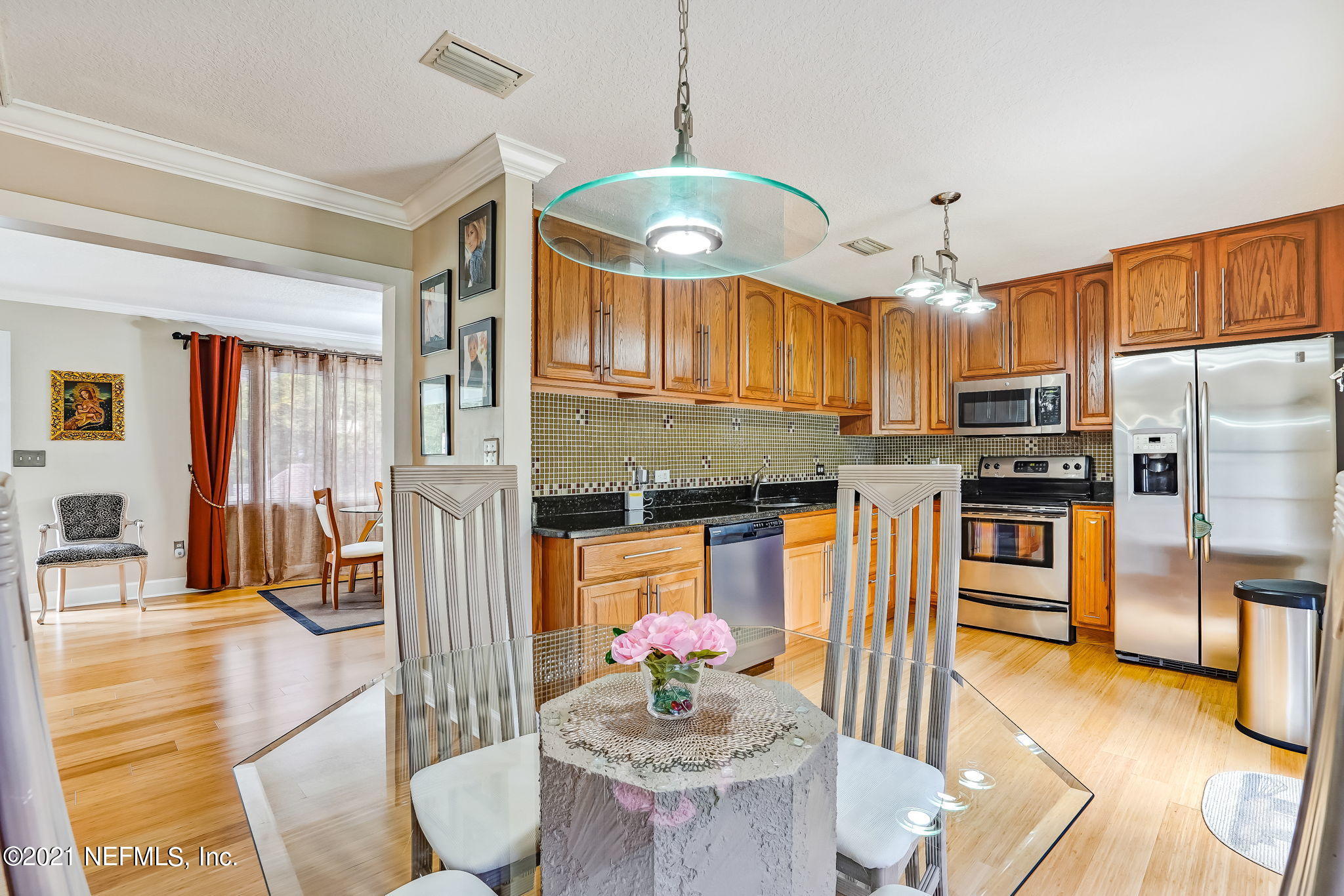 12957 Mandarin Road Jacksonville, FL 32223 - Photo 45 of 83 a kitchen with stainless steel appliances granite countertop a stove a refrigerator a sink a dining table and chairs with wooden floor