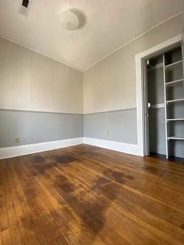 a view of an empty room with closet and a window