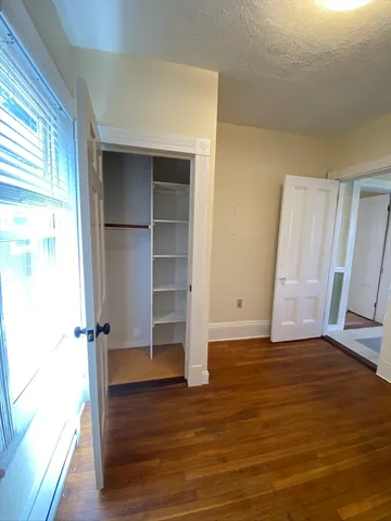 an empty room with wooden floor and closet