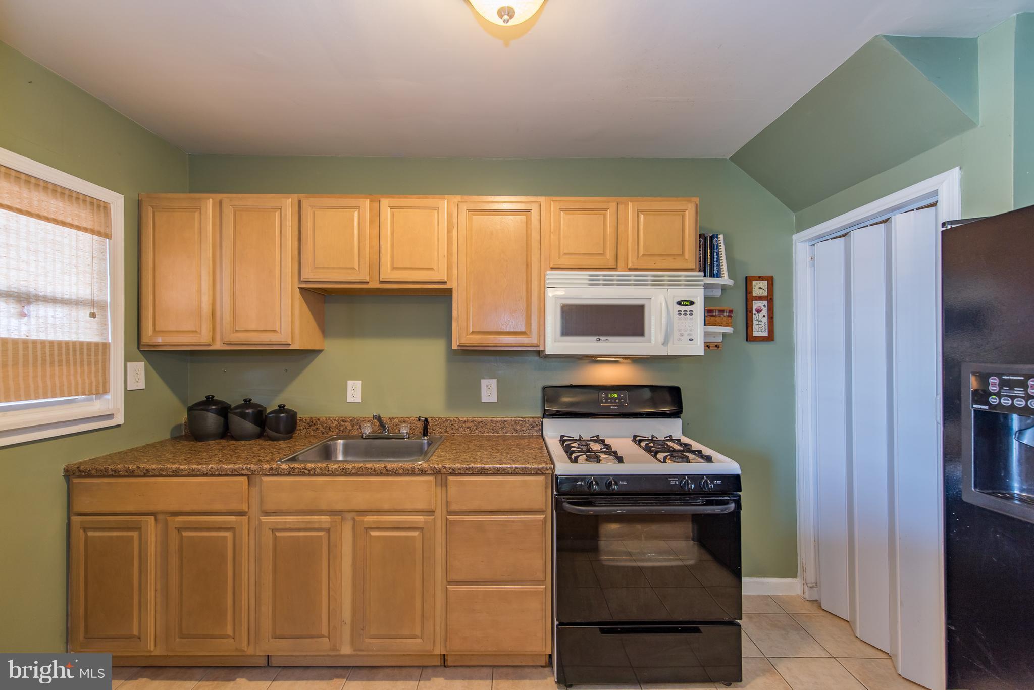 2223 Redthorn Road Baltimore, MD 21220 - Photo 8 of 30 a kitchen with stainless steel appliances granite countertop a stove a sink and a refrigerator