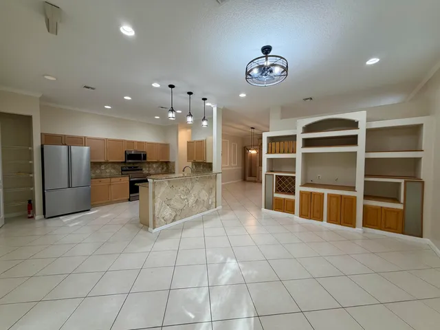 a kitchen with granite countertop a refrigerator sink and microwave