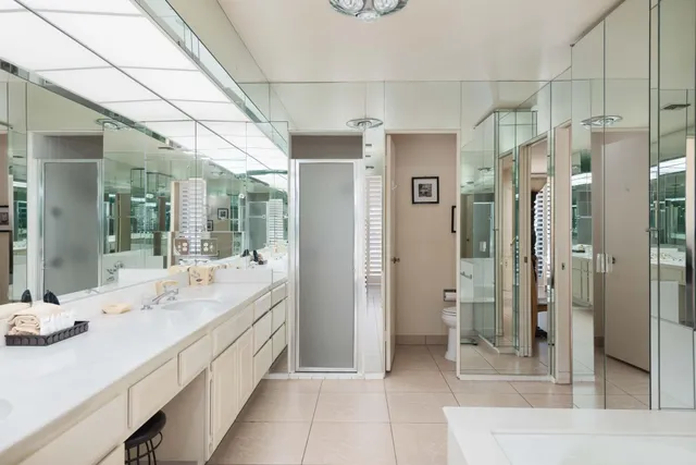 a spacious bathroom with a shower sink and mirror