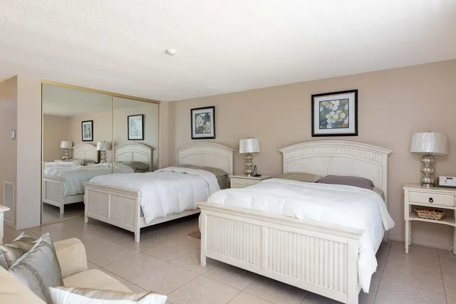 a bedroom with two beds and painting on the wall