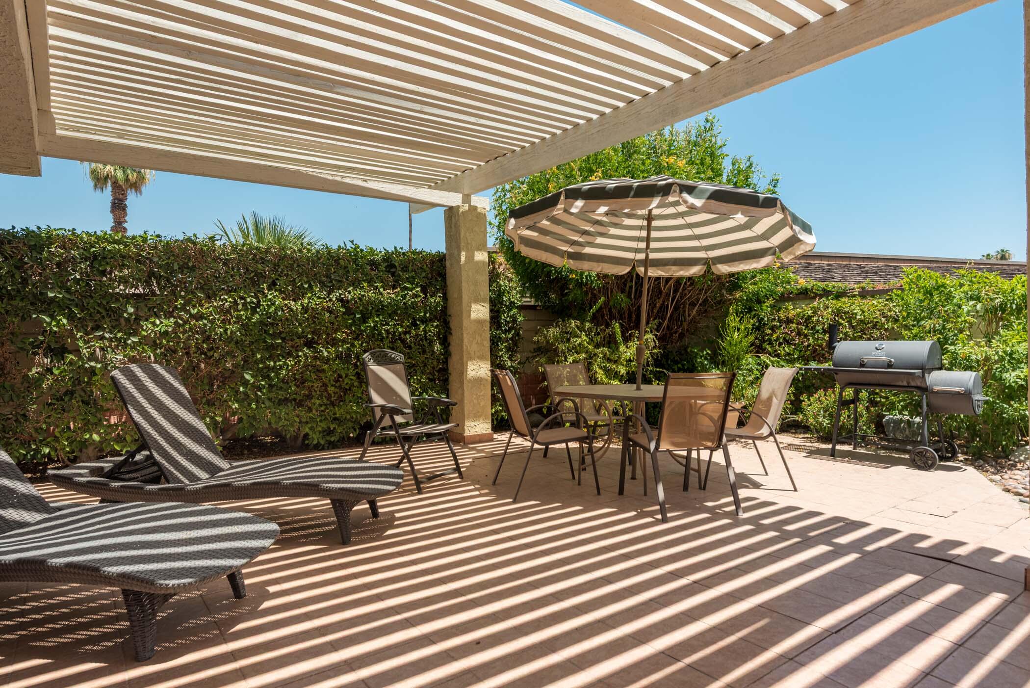 8 Tulane Court Rancho Mirage, CA 92270 - Photo 3 of 31 a view of a patio with table and chairs with wooden floor and fence