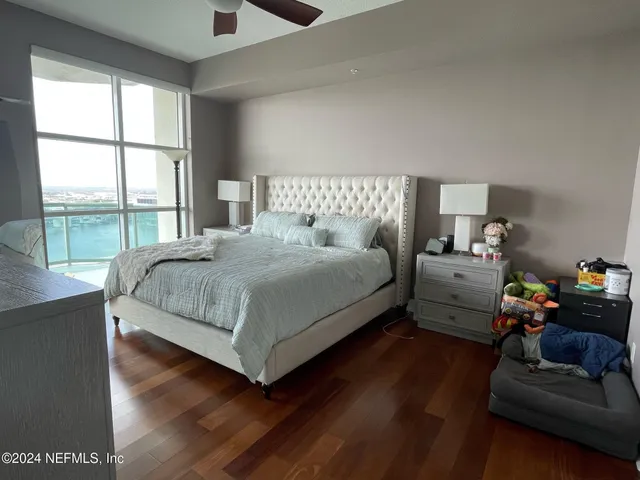 a bedroom with a bed and a couch next to a window