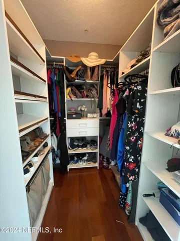 a view of walk in closet with clothes and shoes