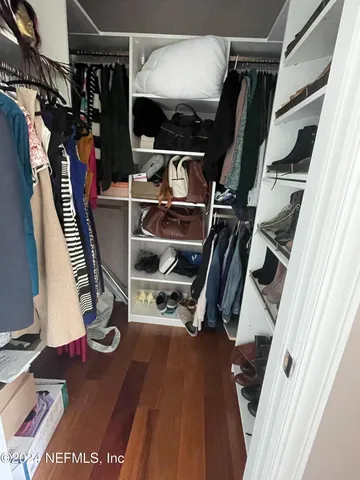 a view of walk in closet with clothes and shoes
