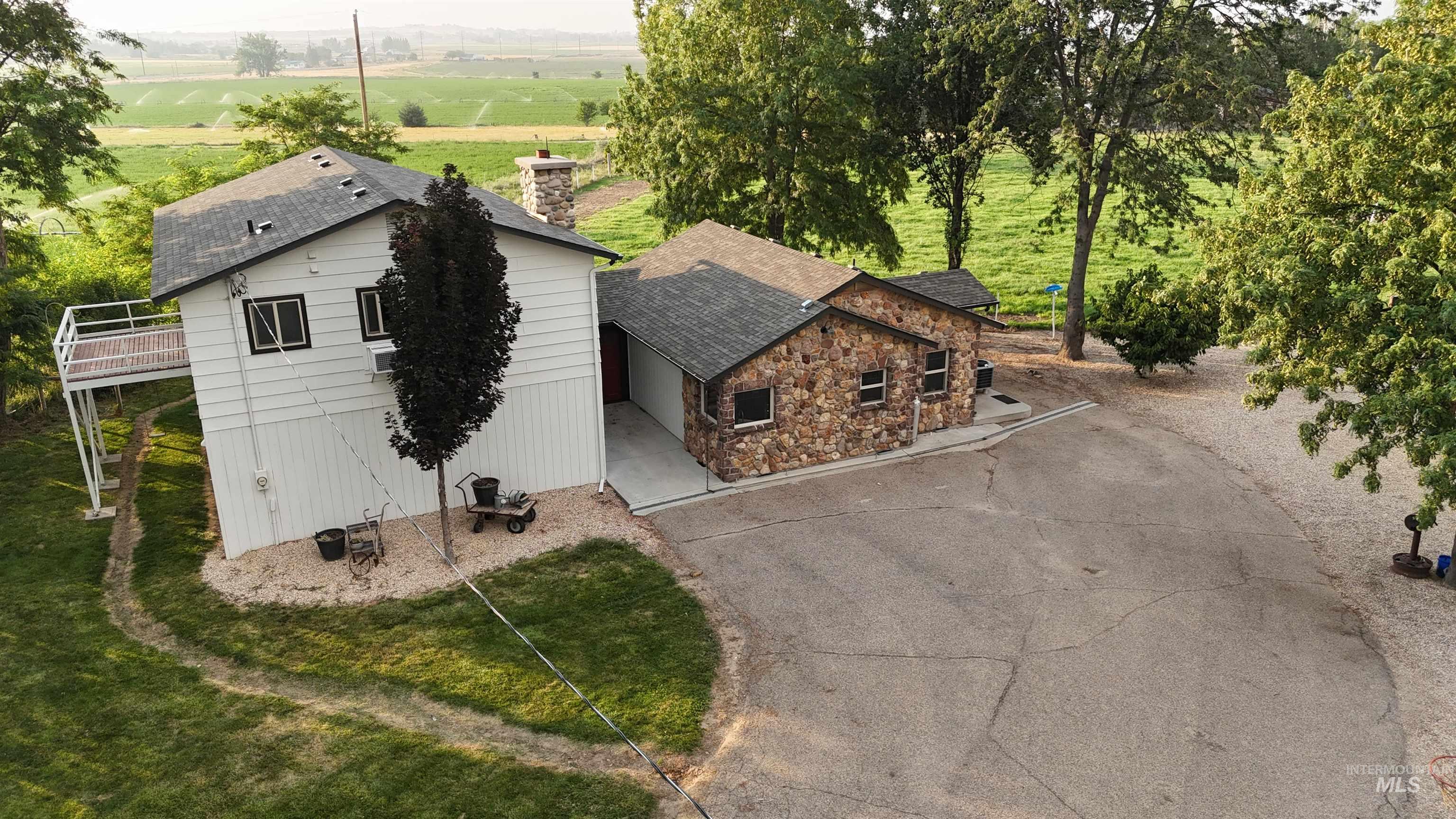 6712 Stage Coach Road Nampa, ID 83686 - Photo 47 of 48 White siding exterior with a dark roof and a stone-clad extension