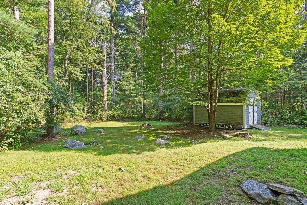7 Flagg Road Acton, MA 01720 - Photo 36 of 39 a view of a backyard with table and chairs and wooden fence