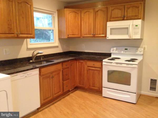 911 Robin Road Silver Spring, MD 20901 - Photo 2 of 15 a kitchen with granite countertop a sink a stove and cabinets