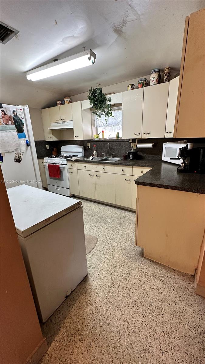 3077 Southwest 5th Street Miami, FL 33135 - Photo 9 of 28 a kitchen with stainless steel appliances granite countertop a sink a stove and a refrigerator
