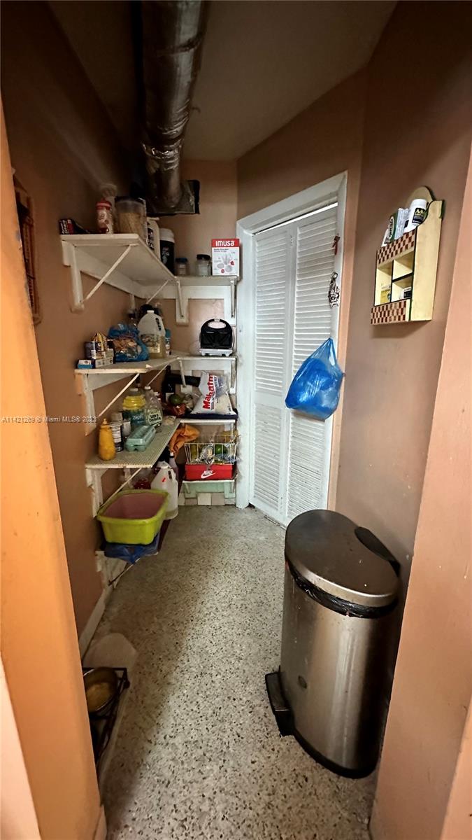 3077 Southwest 5th Street Miami, FL 33135 - Photo 10 of 28 a storage room with water heater and racks