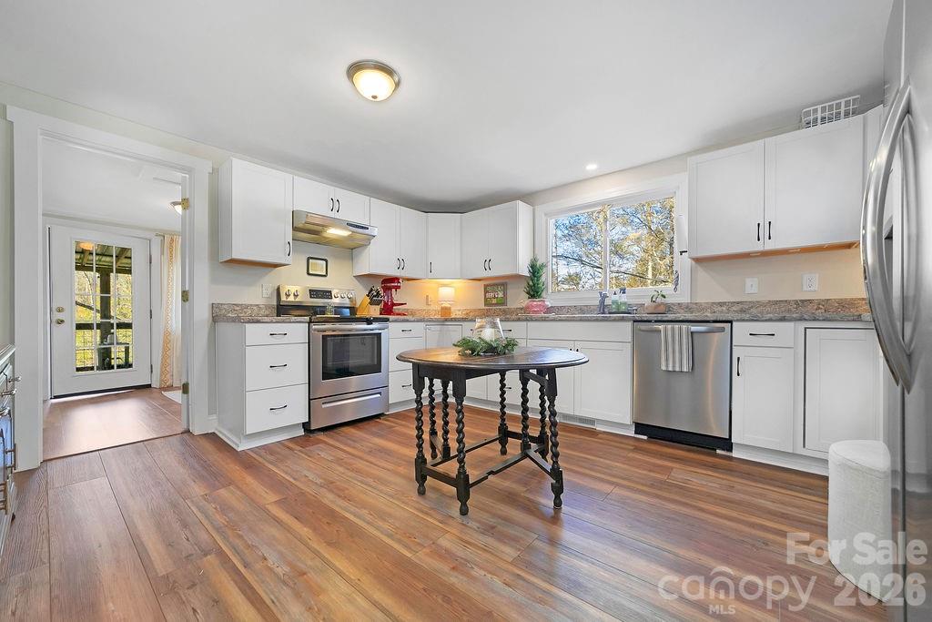 50 Illahee Point Brevard, NC 28712 - Photo 15 of 37 a kitchen with stainless steel appliances a table chairs refrigerator and cabinets