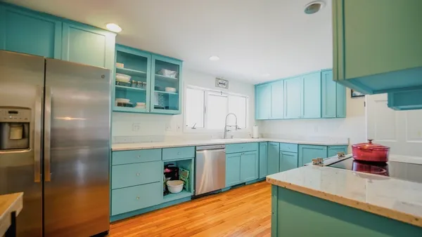 a kitchen with stainless steel appliances kitchen island a sink refrigerator and cabinets