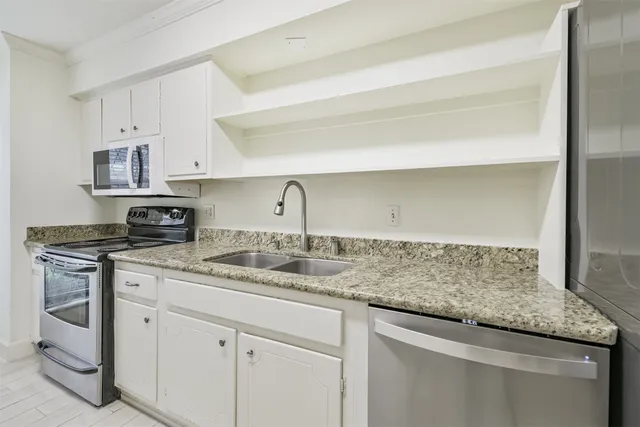a kitchen with stainless steel appliances granite countertop a sink and cabinets