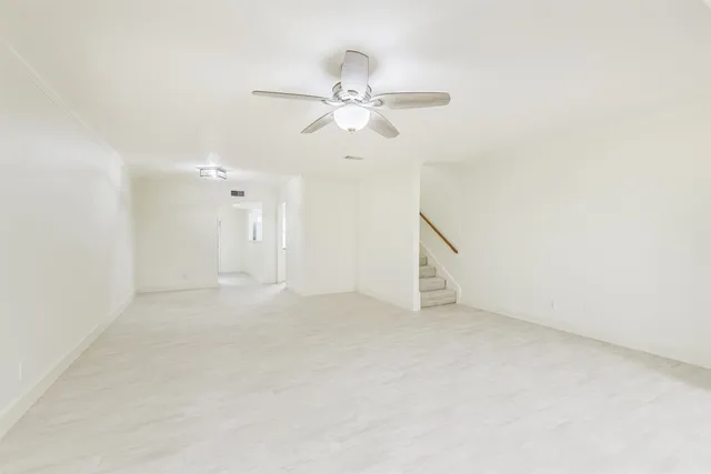 an empty room with chandelier fan