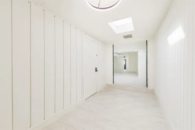 a view of a hallway with wooden shelves