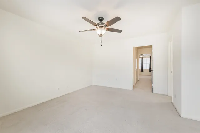 a view of a hallway with a ceiling fan