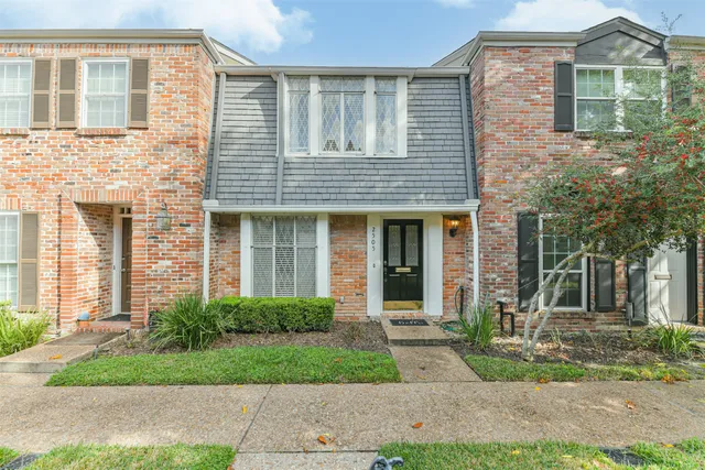 front view of a brick house with a yard
