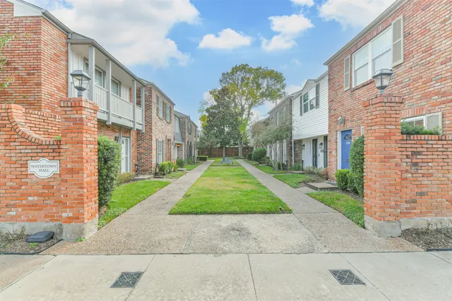 a view of a large brick building next to a yard