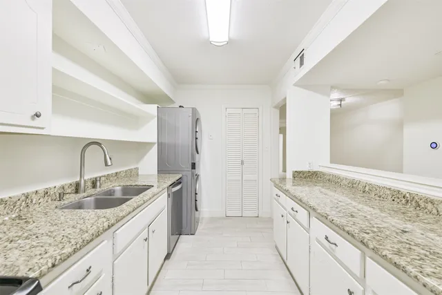 a spacious bathroom with a granite countertop double vanity sink a mirror and a shower