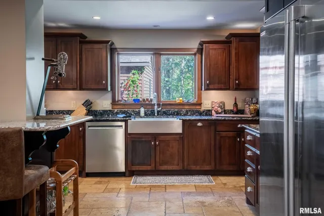 a kitchen with granite countertop a sink and a refrigerator