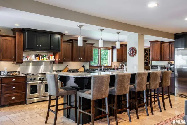 a large kitchen with stainless steel appliances granite countertop a stove a sink dishwasher and cabinets with wooden floor