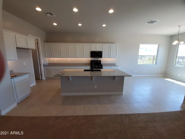 a view of kitchen with windows and refrigerator