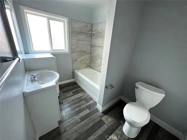 a bath room with a sink a toilet and a window
