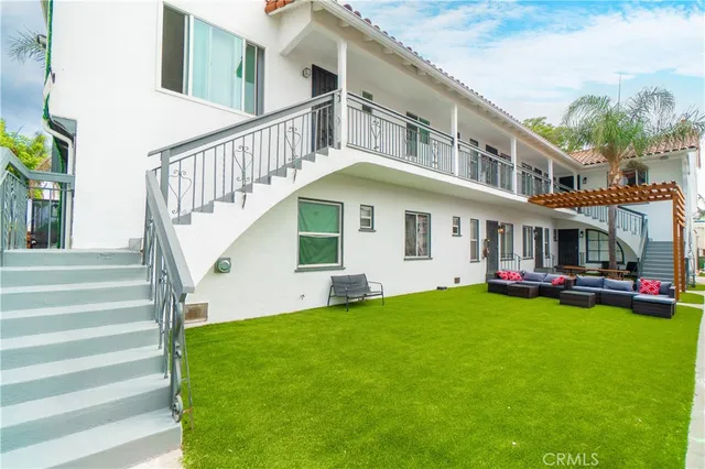 a view of a house with a big yard and large trees