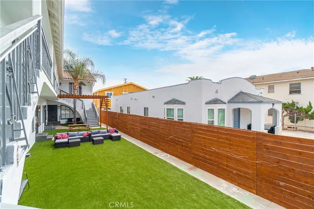a view of a balcony with stainless steel appliances wooden floor and fence