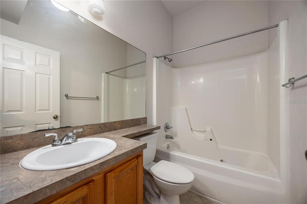 3510 Southwest 30th Way, Unit 158 Gainesville, FL 32608 - Photo 23 of 27 a bathroom with a granite countertop sink toilet mirror and shower