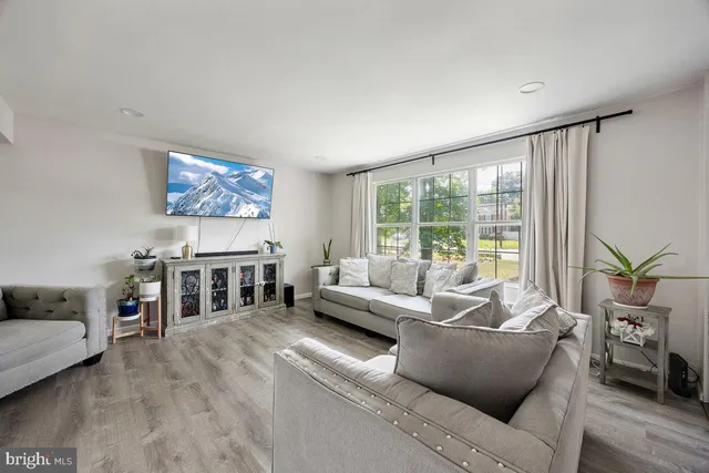 a living room with furniture and a flat screen tv with wooden floor