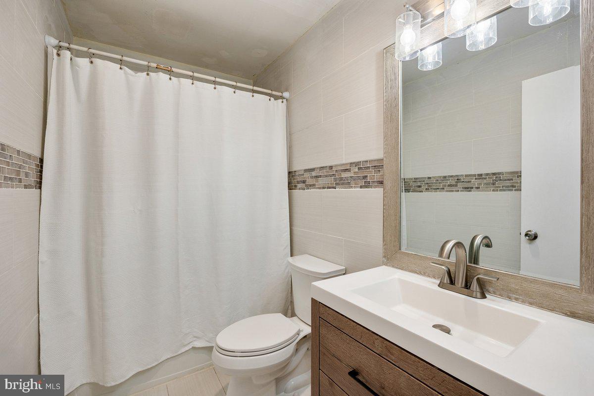8275 Maple Avenue Pennsauken, NJ 08109 - Photo 15 of 43 a bathroom with a sink a toilet and shower curtain