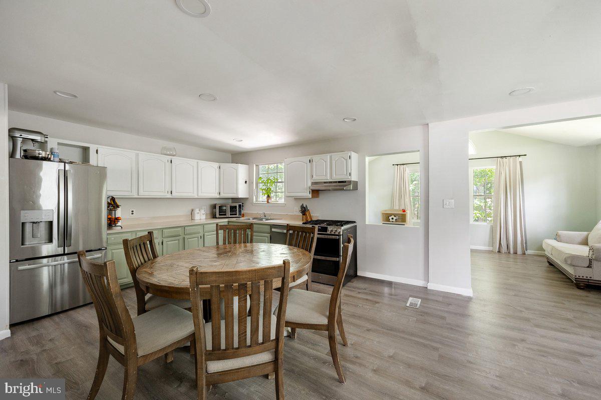 8275 Maple Avenue Pennsauken, NJ 08109 - Photo 3 of 43 a kitchen with stainless steel appliances a dining table chairs refrigerator and microwave