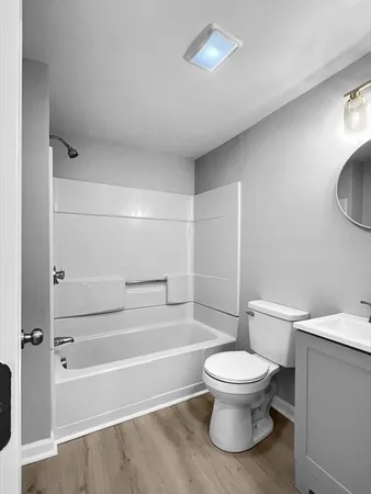 a bathroom with a white toilet and a tub