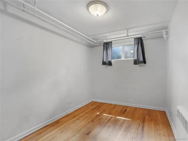 a view of a room with wooden floor and cabinet