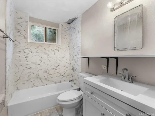 a bathroom with a sink a toilet and bathtub