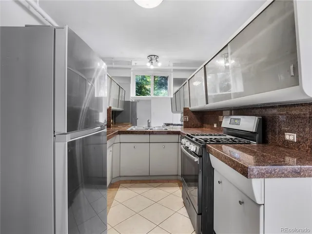 a kitchen with stainless steel appliances granite countertop a stove a refrigerator and a sink
