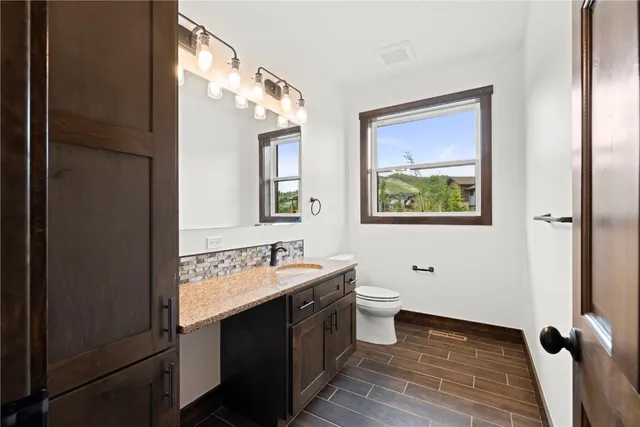 a bathroom with a double vanity sink toilet and a mirror