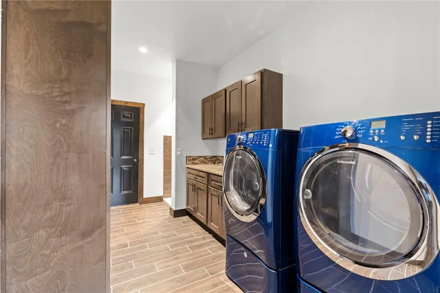 a kitchen with granite countertop a refrigerator and a wooden floor