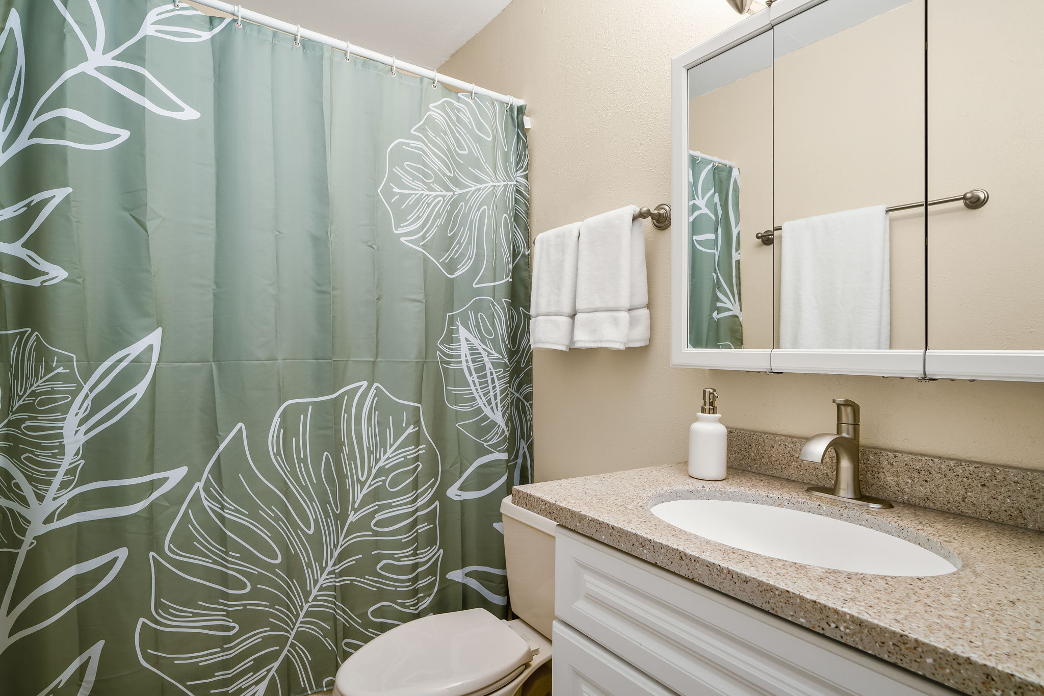 4451 Moana Road, Unit 309 Waimea, HI 96796 - Photo 14 of 21 a bathroom with a granite countertop bathtub sink vanity mirror and toilet
