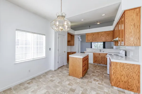 a view of a kitchen with granite countertop stainless steel appliances a sink cabinets and a window