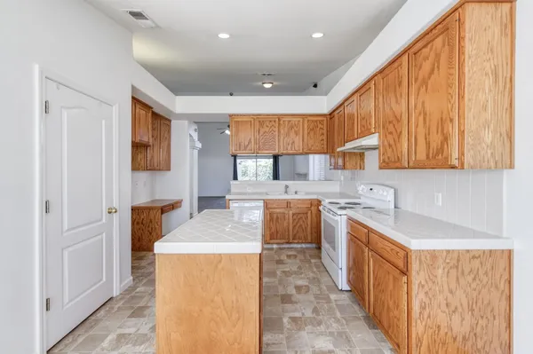 a kitchen with stainless steel appliances granite countertop a sink a stove and a refrigerator