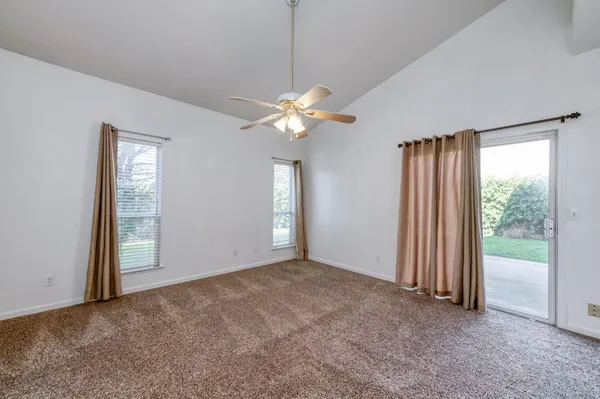 an empty room with fan and windows