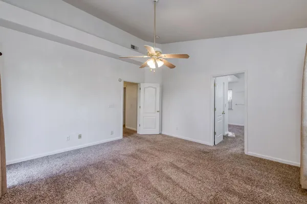 a view of an empty room with a ceiling fan