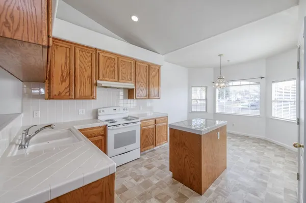 a kitchen with a stove top oven sink and cabinets