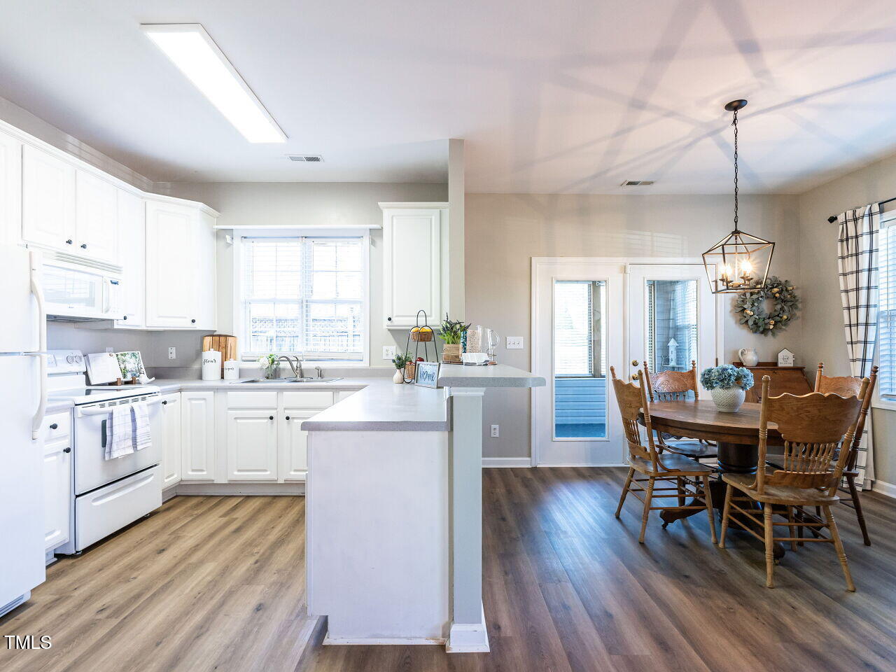 2740 Andover Glen Road Raleigh, NC 27604 - Photo 5 of 20 a kitchen with sink microwave dining table and chairs